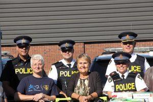 In September, the Hawkesbury OPP detachment collected food for the Hawkesbury Central Food Bank. Officers, assisted by local school children, pushed the food donations in shopping carts from the police station to the food bank. OPP Detachment Commander Franca (Frankie) Campisi is seen at the far right, next to Hawkesbury Mayor Jeanne Charlebois. (Photo: Tara Kirkpatrick)