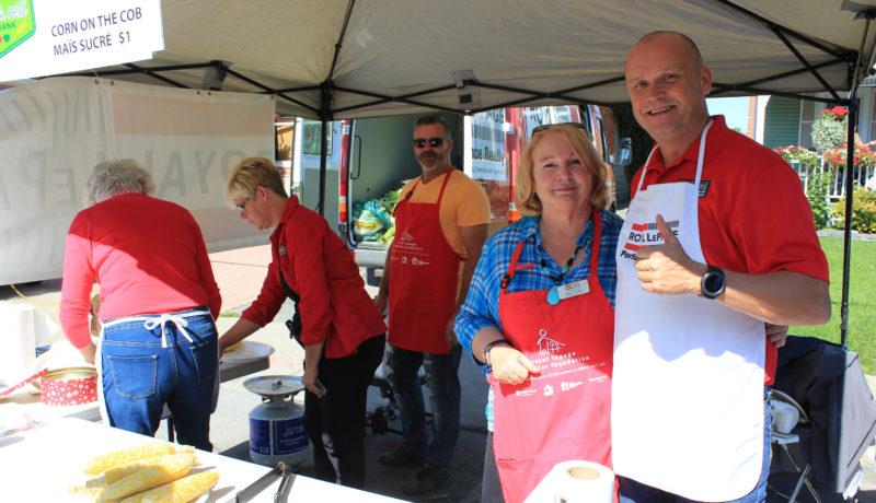 Steven Levac and Nancy Fielding of Royal Lepage Realty serving corn on the cob at their kiosk.