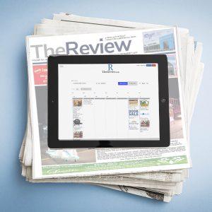 An image of a stack of newspapers with a tablet sitting on top. On the screen of the tablet is a view of the event calendar on TheReview.ca which is part of the Advertise Your Event Package for busy organizers.
