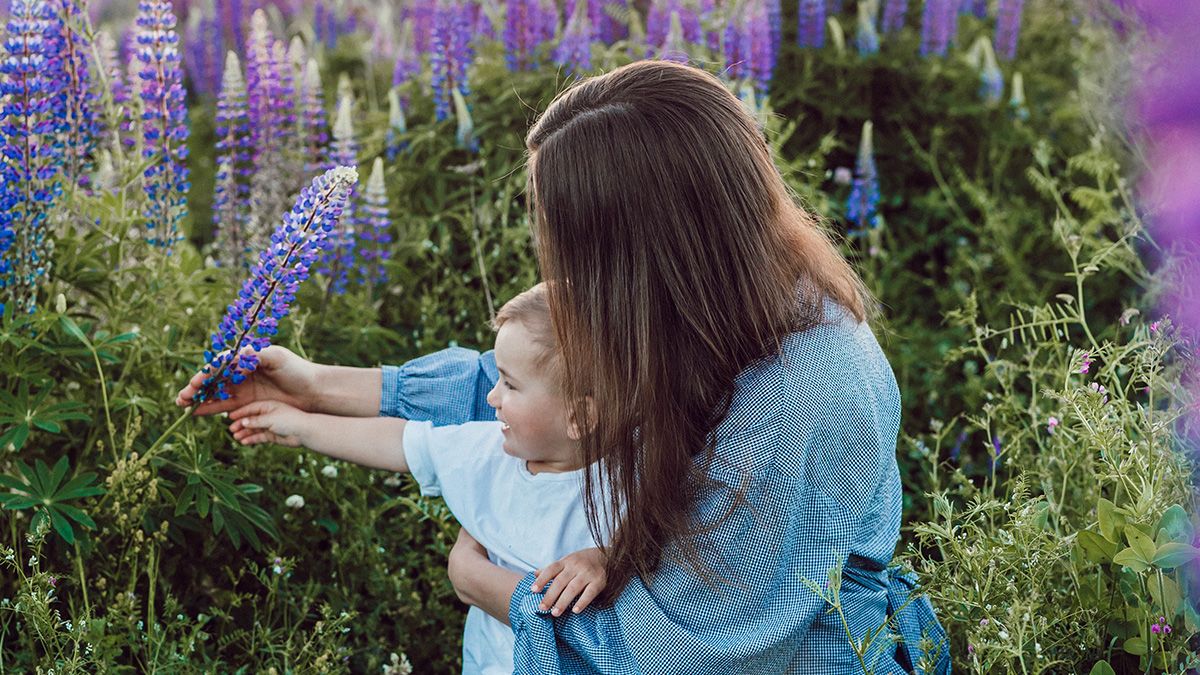Mother's Day photo of mom and small child in field of flowers Photographer Liana Mikah
