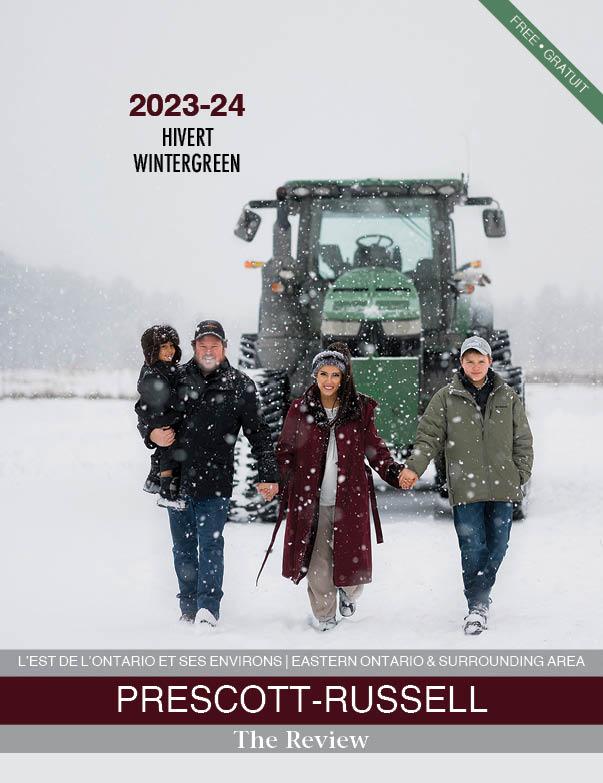 This is an image for the front cover of the 2022-23 WinterGreen Magazine one of the Prescott-Russell Tourism Magazine Publications The Review does each year. It has two children a boy and a girl in winter coats and hats sitting in the snow having fun and smiling